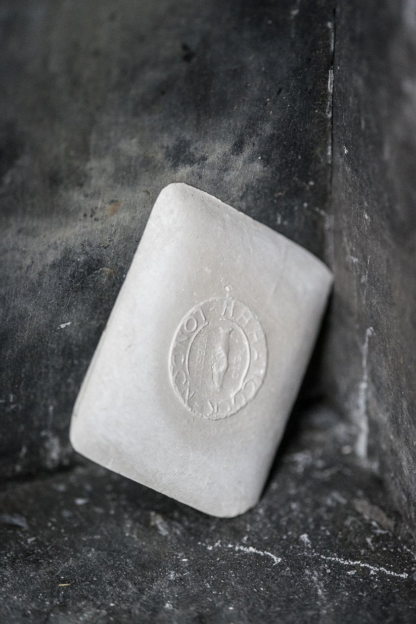 portrait image, white tailors chalk, angled lean on black rustic background.