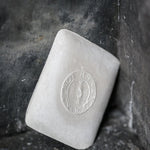 portrait image, white tailors chalk, angled lean on black rustic background.